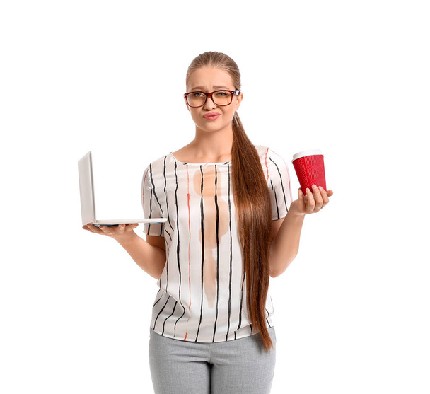 Молодая женщина с пятнами от кофе на футболке и ноутбуке на белом фоне - Фото, изображение
