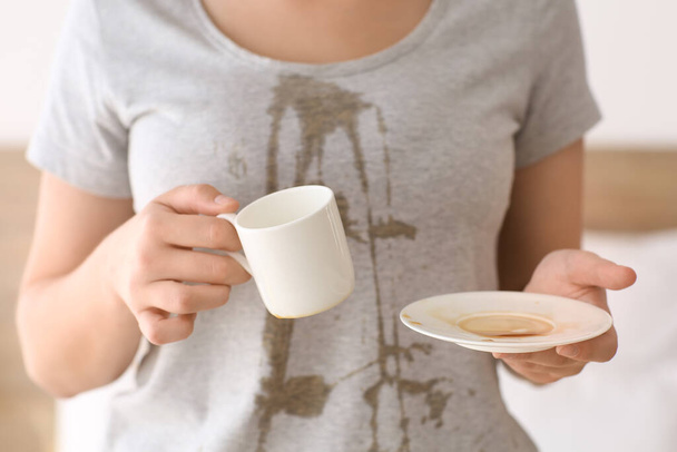 Young woman with coffee stains on her t-shirt in bedroom, closeup - Fotoğraf, Görsel