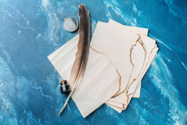 Stylo plume, encre, feuilles de papier et boussole sur la table - Photo, image