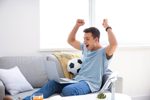 Happy man after winning his sports bet at home - 写真・画像
