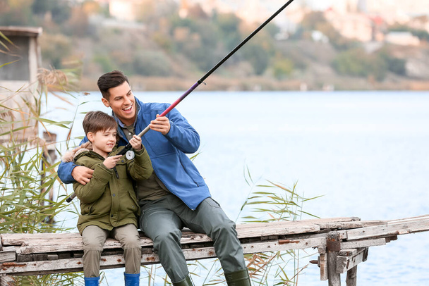 Menino e seu pai pescando no rio - Foto, Imagem