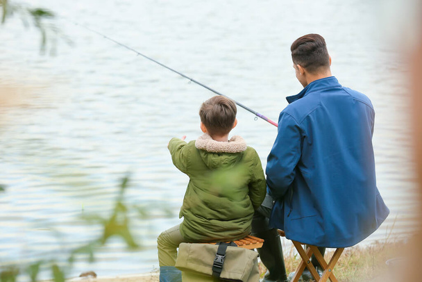 Kleiner Junge und sein Vater fischen im Fluss - Foto, Bild