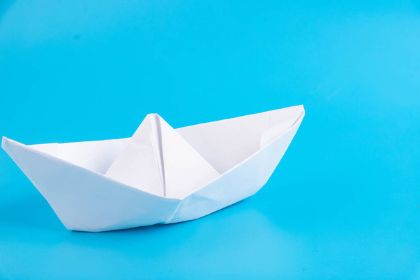 Paper boat on a blue background. Faith symbol, hope. - Zdjęcie, obraz