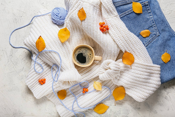 Красивая осенняя композиция с одеждой и чашкой кофе на белом фоне - Фото, изображение