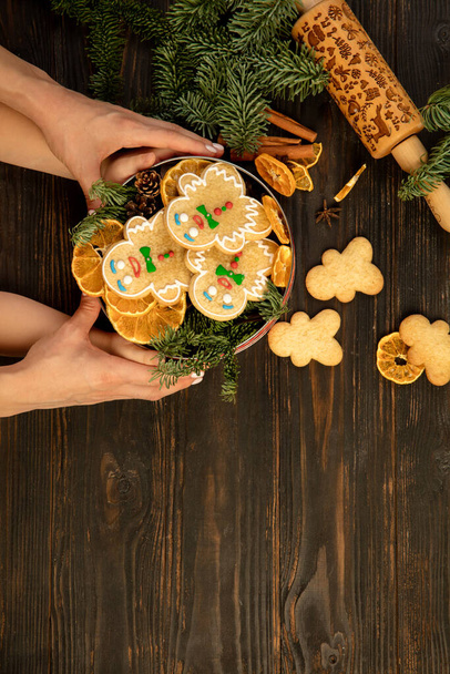 Mani femminili e bambino che tengono la scatola di biscotti regalo di Natale con uomini di pan di zenzero. - Foto, immagini