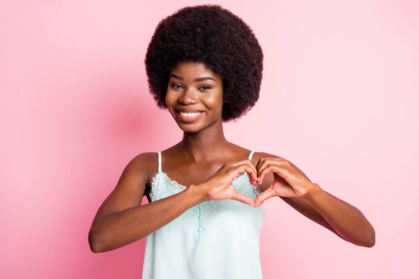 Fénykép a boldog barna hajú fiatal nő, hogy a kezét szív alakú romantikus hangulat elszigetelt rózsaszín színű háttér - Fotó, kép