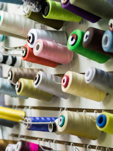 Барвисті нитки використовуються в тканинній та текстильній промисловості. Концепція швейного виробництва
. - Фото, зображення