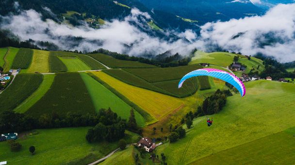 Paragliding through the clouds. Beautiful landscape. Extreme sport. View from above. High quality photo - Photo, Image