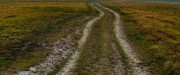 Dirt road cutting through grass plains. . High quality photo - Foto, Imagem