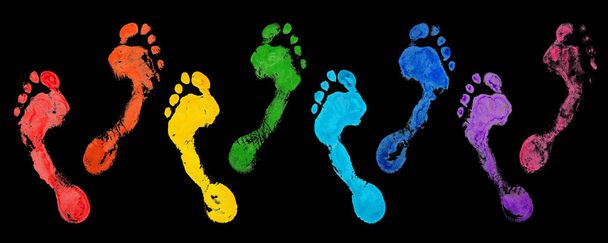 Regenboog kleur menselijke voetafdrukken set zwarte achtergrond geïsoleerd close-up, kleurrijke neon licht voetafdruk illustratie, groep van blootsvoets voetstappen, blote voeten stempel, afdruk, mark, teken, symbool, behang - Foto, afbeelding