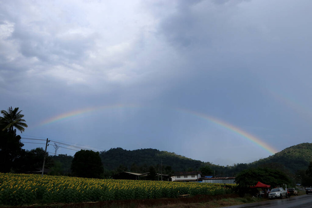 Rainbow light is formed in the sky, area, country road. - Photo, Image