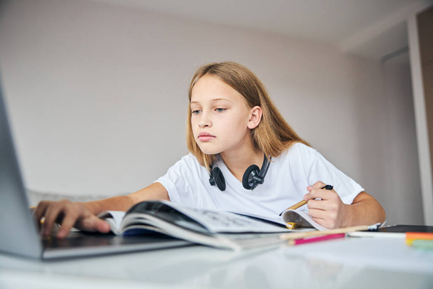 Calm teenage girl using internet on the laptop - Zdjęcie, obraz