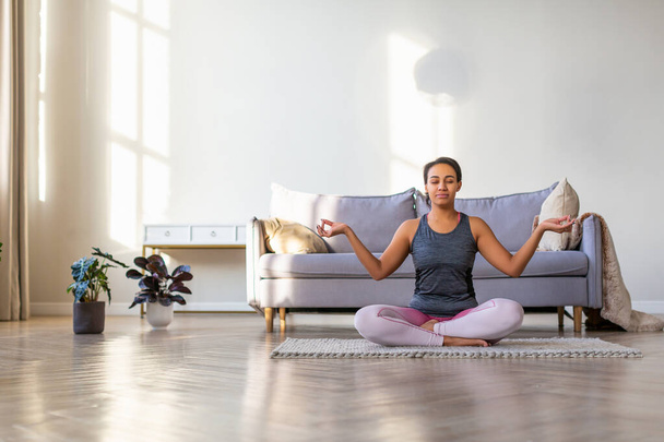 Yoga zu Hause. Afroamerikanerin meditiert. - Foto, Bild