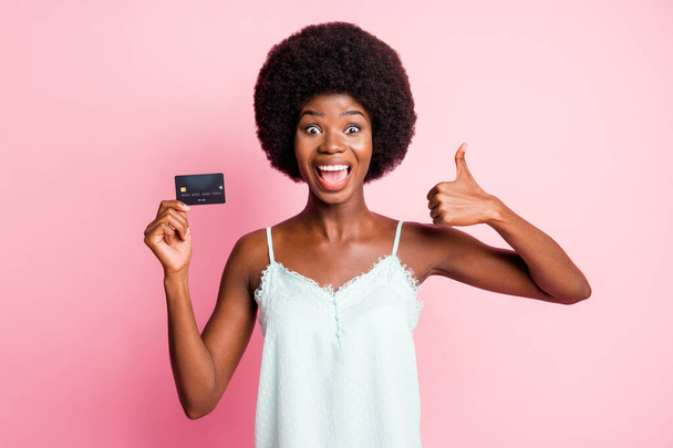 Photo of happy pretty brown haired woman show thumb up hold credit card buy shop pay wear tank-top isolated on pink color background - Photo, Image
