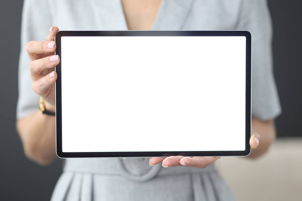 Vrouwelijke handen houden tablet met wit scherm vast - Foto, afbeelding