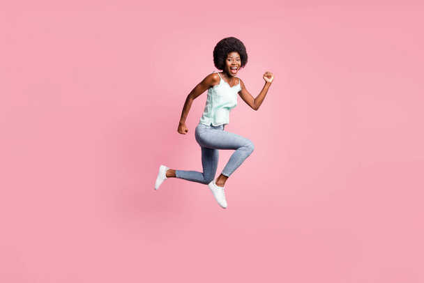 Full body photo of attractive wavy hairdo lady fists up jump open mouth blue singlet isolated on pink color background - Foto, afbeelding