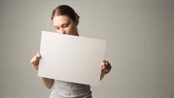 Girl holding white blank sign - Фото, изображение