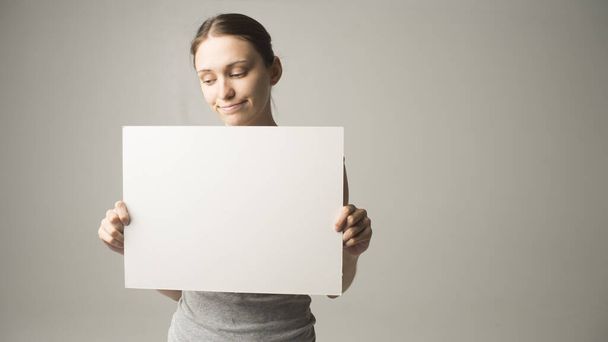Girl holding white blank sign - Фото, изображение