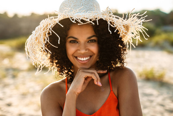 Image of happy positive young african woman posing at the beach outside - Φωτογραφία, εικόνα