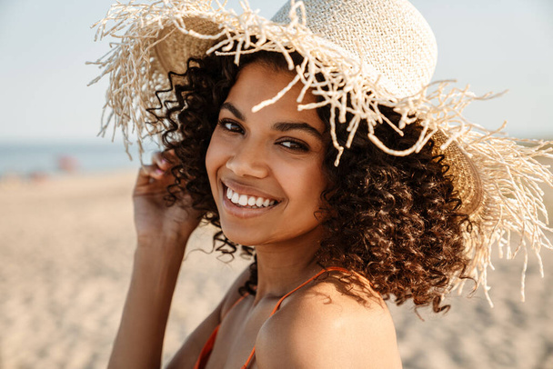 Image of happy positive young african woman posing at the beach outside - Foto, Imagem