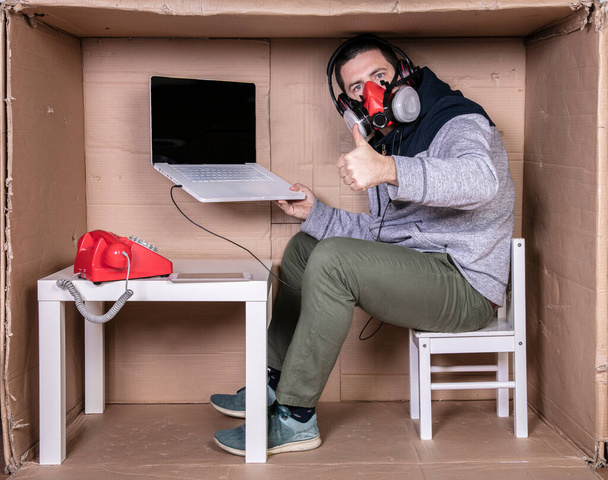 employee works from his own cardboard office to isolate himself from others - Φωτογραφία, εικόνα