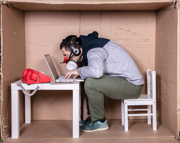 employee works from his own cardboard office to isolate himself from others - Fotoğraf, Görsel