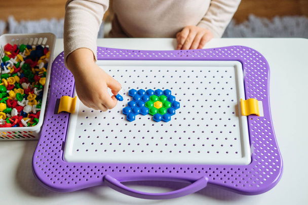 Enfant joue avec puzzle mosaïque à la maison. Jeu créatif pour enfants pour le développement précoce et la motricité fine. - Photo, image