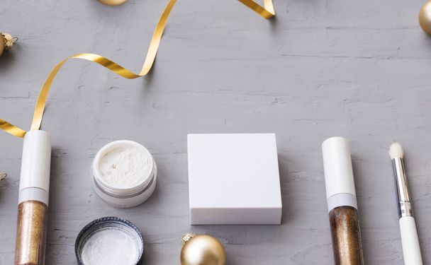 化粧品やクリスマスボールと冬のテンプレート。グレー、ゴールド、ホワイトの3色。メイクアップアーティストと美容室のためのカード. - 写真・画像