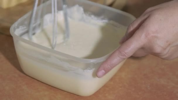 Köchin mischt mit ausgeschaltetem Mixer Eigelb mit Zucker in einer Glasschüssel. - Filmmaterial, Video