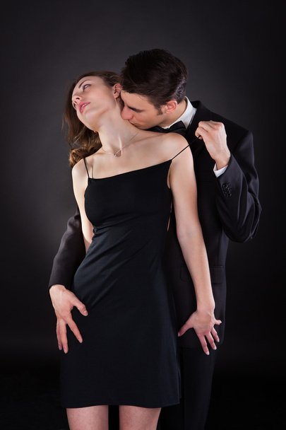Man Kissing Woman On Neck While Removing Dress Strap - Foto, immagini