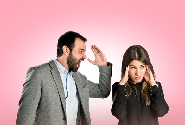 Businessman screaming at his girlfriend over pink background  - Photo, Image