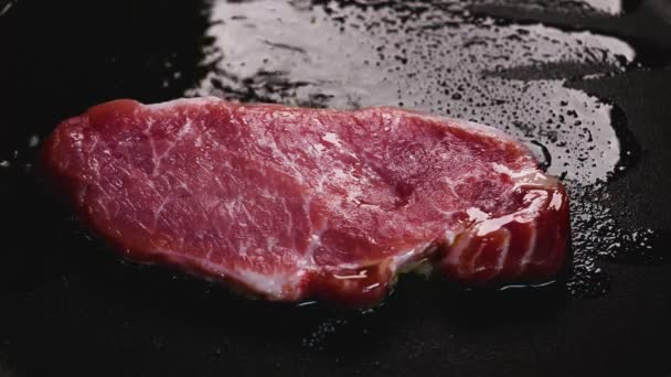 Verse Iberische varkenslende op de grill, koken met tang en pan spetterende olie en bruinen van het vlees. - Video