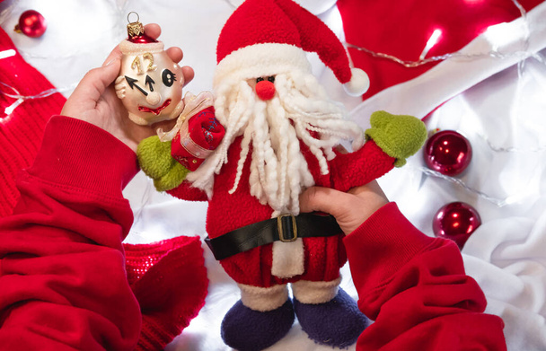 Trzymaj w rękach cute zabawka Santa Claus i choinka zabawka w postaci zegara, który mówi pięć minut do 12 rano. 5 minut przed nowym rokiem jest czas na życzenie.. - Zdjęcie, obraz