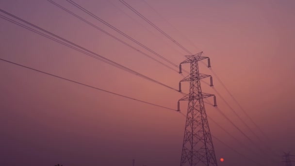 Torre eléctrica con vista al atardecer rodaje cinematográfico sobre fondo de cielo púrpura. - Metraje, vídeo