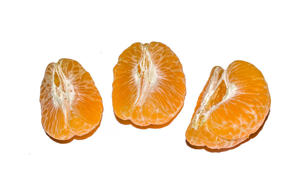 gepeld sappig sinaasappelfruit met stukjes geïsoleerd op wit. - Foto, afbeelding