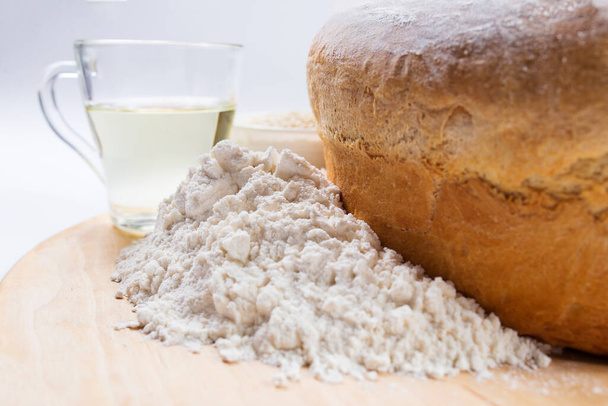Pieczony chleb z mąki pszennej ze składnikami z bliska, na białym tle. - Zdjęcie, obraz