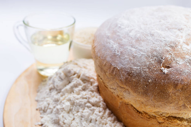 Vain paistettu valkoinen vehnäjauho leipää lähikuva ainesosia. - Valokuva, kuva