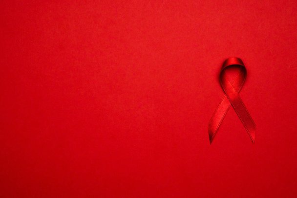 Cancer du sein femme. Ruban rouge symbole dans la journée du monde hiv sur fond rouge foncé. Aides à la sensibilisation et cancer. Soins de santé et concept médical - Photo, image