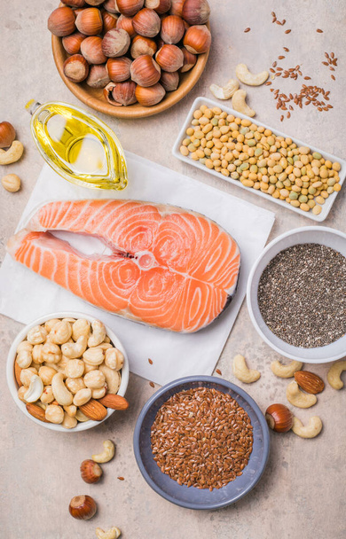 Omega 3 food sources and omega 6 on concrete background, top view copy space. Foods high in fatty acids including vegetables, seafood, nut and seeds - Photo, Image