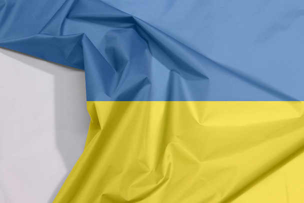 Bandera de tela de Ucrania crepé y pliegue con espacio en blanco, es una bandera de dos bandas horizontales de igual tamaño de azul y amarillo. - Foto, imagen