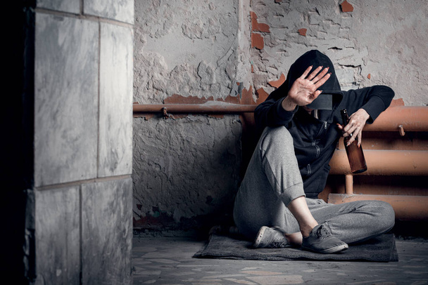 El concepto de drogadicción y falta de vivienda. Una mujer deprimida y sin esperanza se sienta después de consumir drogas y alcohol en una casa abandonada. - Foto, Imagen