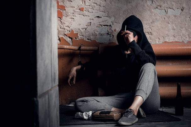 El concepto de drogadicción y síndrome de abstinencia. Una mujer deprimida y sin esperanza sostiene un arma en su mano - Foto, Imagen
