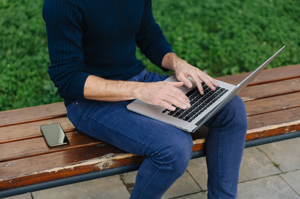 Бизнесмен делает удаленную работу с ноутбуком на открытом воздухе - Фото, изображение
