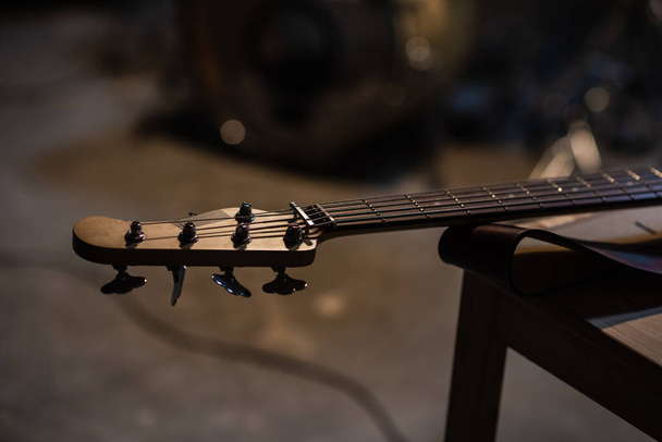 tuning pegs and fretboard bass guitar close up on the background of the musicians apartment with copy space. - 写真・画像