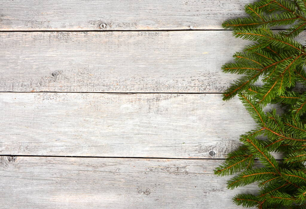 Empty Gray wooden board background with green spruce branches on one side. Christmas background, copy space - 写真・画像