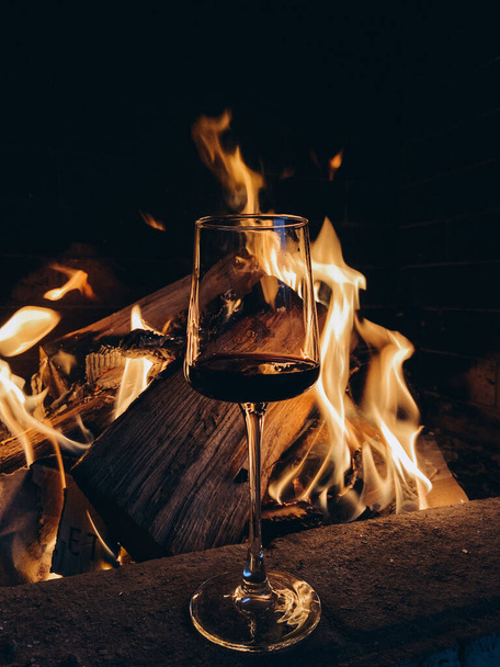 Szklanka czerwonego wina na tle ognia - Zdjęcie, obraz