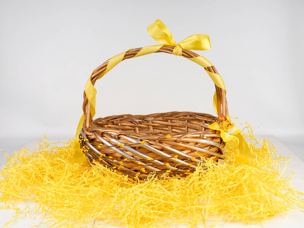 wicker basket with yellow bow, empty straw basket - Φωτογραφία, εικόνα