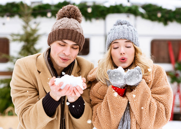 Prima nevicata. Giovane coppia romantica che gioca con la neve, godendo giornata invernale all'aperto - Foto, immagini