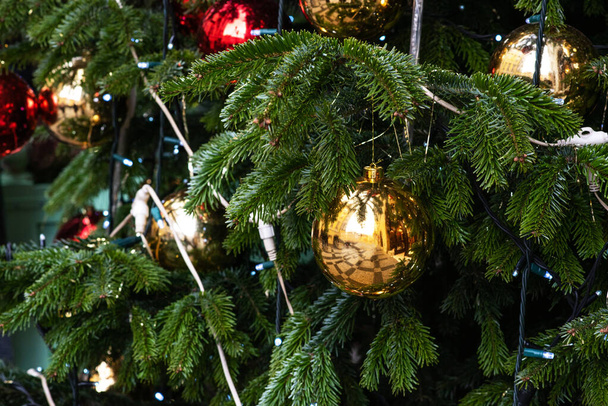 Winter christmas background with fir branches and Christmas balls. Decorated Christmas tree on blurred background. - Foto, imagen