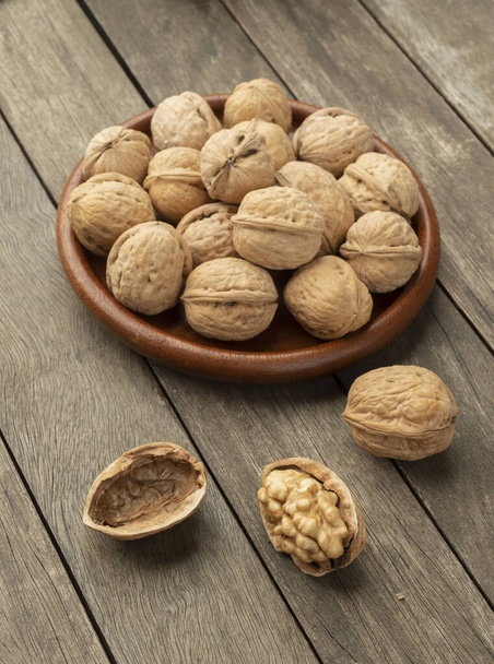 Walnuts over a wooden table and on a plate. - Foto, immagini